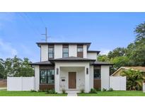 Modern two-story home showcasing a clean white facade with contrasting wood accents and a well-manicured lawn at 5055 2Nd S Ave, St Petersburg, FL 33707