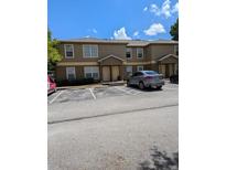 Two-story townhome featuring neutral stucco, ample parking, and close proximity to community amenities at 5915 Brickleberry Ln # 103, Zephyrhills, FL 33541
