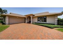 Charming single-story home with a brick driveway, manicured landscaping, and a two-car garage at 671 Tallahassee Ne Dr, St Petersburg, FL 33702