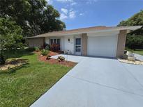 Charming single-story home featuring a well-manicured lawn, colorful landscaping and an attached one-car garage at 700 Bowsprit Pl, Palm Harbor, FL 34685
