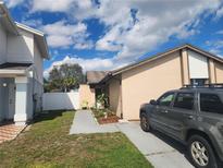 Cozy single-story home featuring a tidy front yard, a paved walkway, and a parked car along the side at 10539 Parkcrest Dr, Tampa, FL 33624