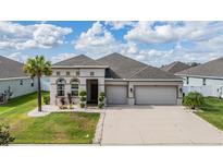 Lovely home with a three car garage, attractive landscaping, and a well-manicured lawn at 12420 Brick Cobblestone Dr, Riverview, FL 33579