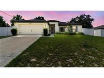 Charming single-story home featuring a two-car garage, manicured lawn, and tasteful landscaping at 27050 Anthony Ave, Brooksville, FL 34602