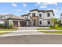 Stunning two-story home featuring a stone facade, attached two-car garage and meticulously landscaped front yard at 33750 Ocean Spray Ln, Wesley Chapel, FL 33543