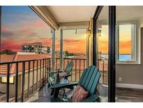 Relaxing balcony view with comfortable chairs and a table setting, perfect for enjoying the sunset at 6158 Palma Del Mar S Blvd # 306, St Petersburg, FL 33715