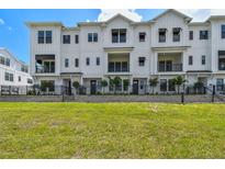 Beautiful exterior of a modern white townhome with a well-maintained green lawn at 7240 Sutton Ln, Sarasota, FL 34240