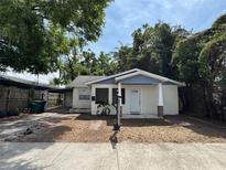 Charming single-story home with a light exterior, covered parking, and a tidy yard at 807 E Elm St, Tampa, FL 33604