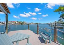 Waterfront home featuring a private dock with seating and scenic water views at 106 Midway Is, Clearwater Beach, FL 33767