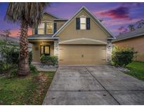 Charming two-story home with a well-manicured lawn and a two-car garage, showcasing its inviting curb appeal at 13246 Kent Bradley St, Dade City, FL 33525