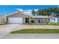 Charming single-story home with a well-manicured lawn, two-car garage, and welcoming front entryway at 13263 86Th Ave, Seminole, FL 33776