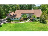 Charming single-story home with manicured lawn, mature landscaping, and a welcoming entryway at 1903 Curry Rd, Lutz, FL 33549