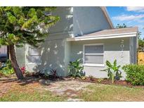 Charming home exterior with a beautifully landscaped front yard and healthy, green plants and trees at 2078 Madrid N Ct, Clearwater, FL 33763
