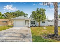 Charming single-story home featuring a well-manicured lawn, attached garage, and inviting front entrance at 2858 State Road 590, Clearwater, FL 33759