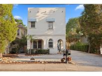 Charming two-story home with a white exterior, blue awnings, and meticulous landscaping at 2936 W Knights Ave # A, Tampa, FL 33611