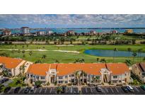 Wide aerial view showcasing community buildings, a golf course and waterfront skyline at 6151 Bahia Del Mar Blvd # 126, St Petersburg, FL 33715