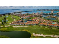 Stunning aerial view of a golf course community with waterfront homes, lush greenery, and a scenic bridge in the background at 6151 Bahia Del Mar Blvd # 126, St Petersburg, FL 33715