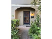 Charming front entrance with secure iron gate and lush landscaping, leading to a welcoming home at 7601 W Deleon Ct, Tampa, FL 33615
