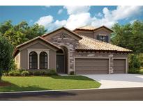 Charming single-story home featuring stone accents, a clay tile roof, a manicured lawn, and an attached two-car garage at 8826 Eastwyck Dr, Parrish, FL 34219