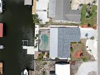 Stunning aerial view of waterfront property with pool, dock, and boat lift access to channel at 916 Sago Palm Way, Apollo Beach, FL 33572