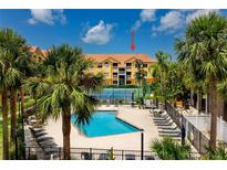 Resort-style condo complex featuring a sparkling pool, tennis court, palm trees and tropical landscaping at 10764 70Th Ave # 5302, Seminole, FL 33772