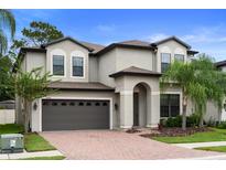 Stunning two-story home boasts a brick driveway, manicured lawn, and a two-car garage at 11006 Tahiti Isle Ln, Tampa, FL 33647