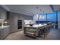 Modern kitchen features a large island with seating, marble countertops, and floor-to-ceiling windows with city views at 1101 E Jackson St # 2302, Tampa, FL 33602