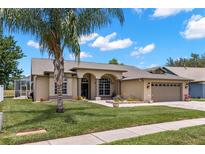 Charming single-story home featuring a manicured lawn, attached two-car garage, and inviting front entrance at 12339 Roseland Dr, New Port Richey, FL 34654