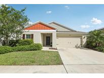 Charming single-story home with a well-manicured lawn, complemented by a two car garage and a welcoming front porch at 12830 Bent Twig Dr, Riverview, FL 33579