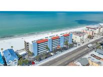 Beautiful aerial view of the condo community nestled along a pristine white sand beach with clear turquoise ocean waters at 13720 Gulf Blvd # 302, Madeira Beach, FL 33708