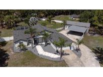 Beautiful home featuring mature landscaping, a screened in lanai, attached garage and separate carport with a long driveway at 27709 Robin Roost Ln, Wesley Chapel, FL 33544