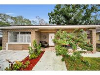 Charming single-story brick home featuring a cozy front porch with stylish outdoor seating and lush landscaping at 314 Bath St, Tarpon Springs, FL 34689