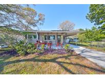 Charming single-story home with a cozy front porch, lush landscaping, and a well-maintained lawn at 3226 20Th N St, St Petersburg, FL 33713