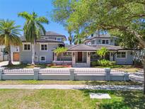 Elegant two-story home featuring a tile roof, manicured landscaping, and a secure wrought iron fence at 405 S Shore Crest Dr, Tampa, FL 33609