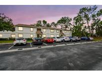 Exterior of condo building showing parking lot with cars and beautiful colorful sunset sky at 413 Meadow Ln # 81, Oldsmar, FL 34677