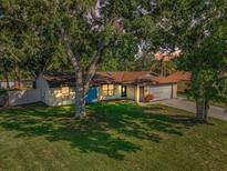Charming single-story home with a well-manicured lawn and mature trees casting dappled shadows at 455 Cypress Lake Ct, Oldsmar, FL 34677
