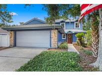 Inviting two-story home with blue siding, brick accents, and a well-manicured lawn at 5032 Cypress Trace Dr, Tampa, FL 33624