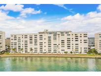 Waterfront condo building featuring multiple stories, balconies, and lush landscaping in a picturesque setting at 6020 S Shore Blvd # 709, Gulfport, FL 33707