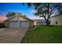 Charming home featuring a well-manicured lawn, stone accents, and a spacious two-car garage at 6914 Harbor Dr, Hudson, FL 34667