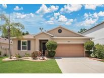 Charming single-story home featuring a well-manicured lawn, mature landscaping, and an attached two-car garage at 7518 Tangle Brook Blvd, Gibsonton, FL 33534