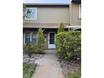 Inviting front entrance to this townhome with manicured landscaping and walkway at 7605 W Deleon Ct, Tampa, FL 33615