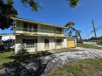 Two-story brick home with a wrought iron balcony and attached yellow garage door at 8244 125Th St, Seminole, FL 33772