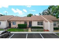 Inviting townhouse with tidy landscaping, beige stucco, and convenient parking at 1041 Bowsprit Ln # 1041, Holiday, FL 34691