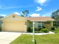 Charming single-story home with a manicured lawn, two-car garage, and inviting front entrance at 10806 Brookhaven Dr, New Port Richey, FL 34654