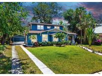 Charming two-story home with a lush green lawn and beautiful landscaping at 112 W Mohawk Ave, Tampa, FL 33604