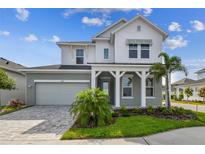 Charming two-story home with manicured lawn, lovely landscaping and a welcoming front porch at 1586 Running Tide Pl, Sarasota, FL 34240