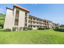 Low angle shot of a condominium complex with green grass and balconies at 3055 Casa Del Sol Cir # 202, Clearwater, FL 33761
