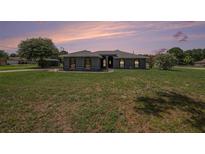Charming single-story home with a well-maintained lawn and an attractive facade at dusk at 31645 Bugle Ln, Wesley Chapel, FL 33543