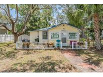 Charming single-story home featuring a brick path, white picket fence, and ample foliage at 526 5Th N Ave, Safety Harbor, FL 34695