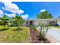 Charming single-story home featuring a well-maintained lawn and an attached two-car garage at 6705 Ranger Dr, Tampa, FL 33615