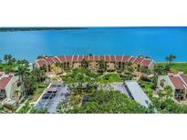 Panoramic aerial view of a condo complex boasting lush landscaping and beautiful bay views on a sunny day at 7520 Sunshine Skyway S Ln # 113, St Petersburg, FL 33711